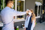 A schoolgirl undergoes a temperature screening as part of COVID-19 safety measures.