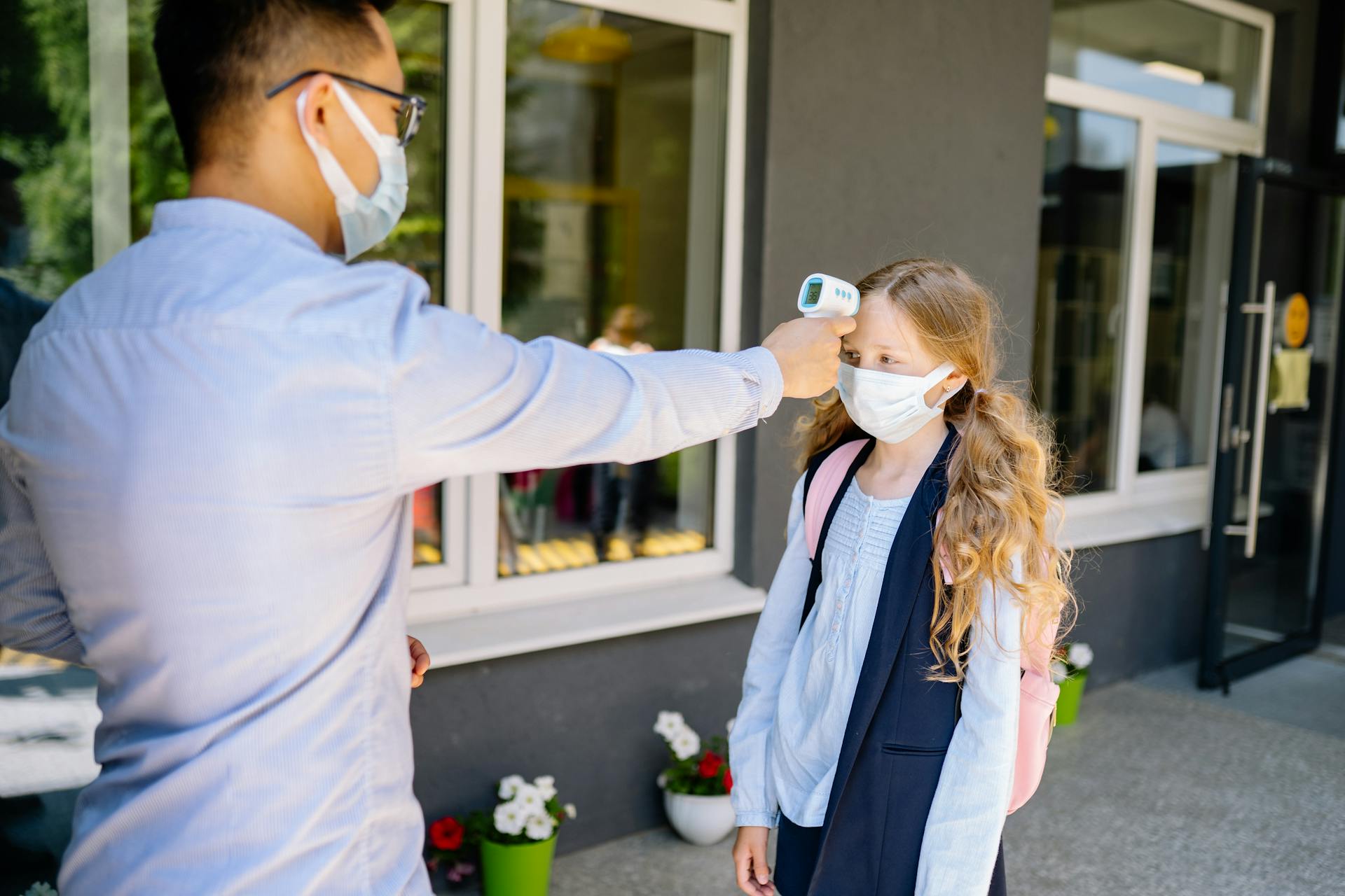 A schoolgirl undergoes a temperature screening as part of COVID-19 safety measures.
