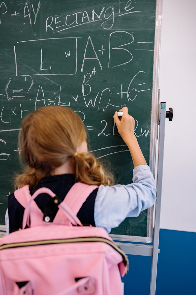 A Girl Writing On A Blackboard