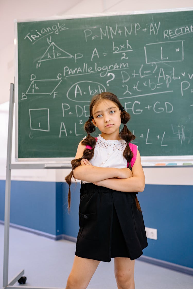 A Confident Girl Standing In Front Of The Blackboard