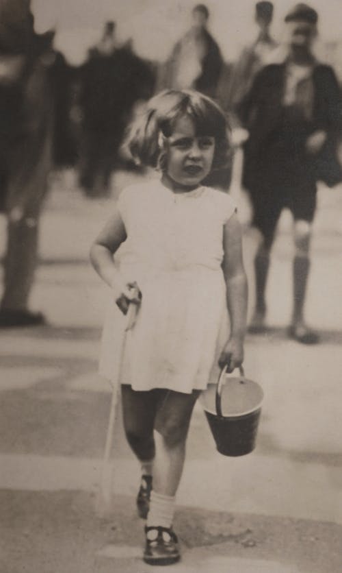 Lost Girl in White Sleeveless Dress Holding Bucket