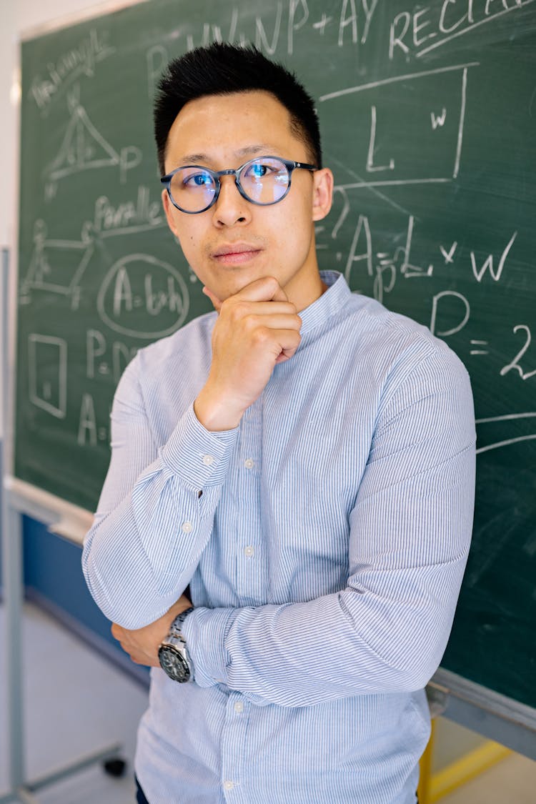 Male Teacher In Blue Long Sleeve Shirt Contemplating