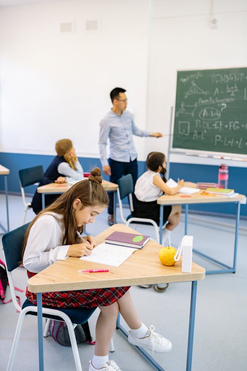 Teacher Teaching a Lesson to Students Inside the Classroom