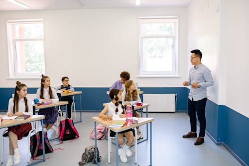 Children Looking at a Man Inside the Classroom