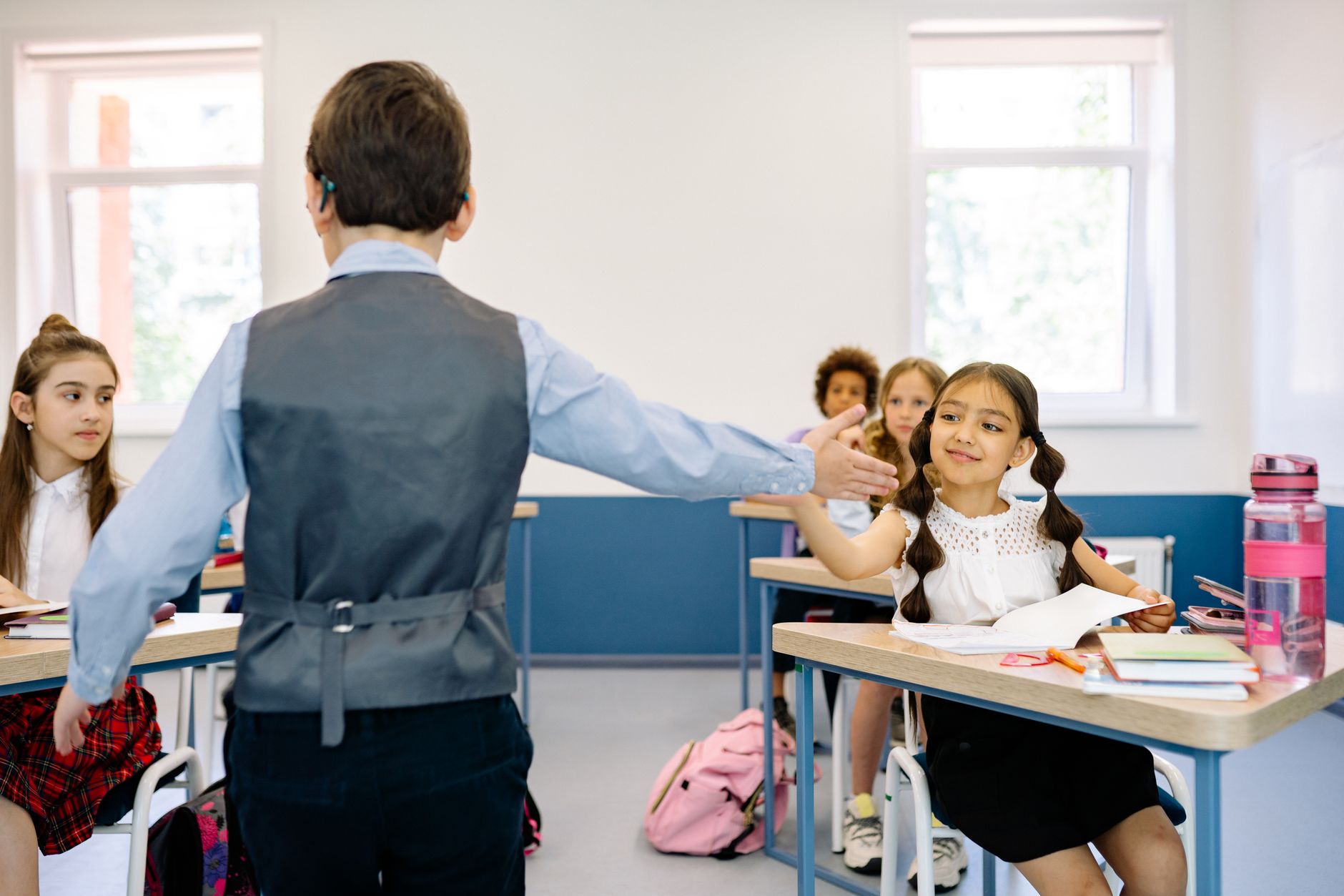 Dois estudantes em mediação com orientador escolar em sala acolhedora, demonstrando diálogo construtivo e resolução de conflitos
