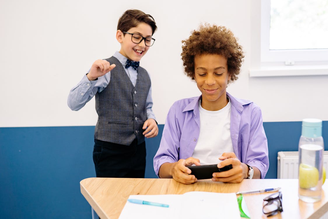Free Boy in White Shirt and Purple Button Up Shirt Holding Black Mobile Phone Stock Photo