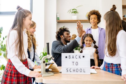 Happy students with a teacher celebrating 'Back to School' indoors. 8617813