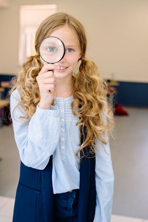 Free A Girl Holding a Magnifying Glass Stock Photo