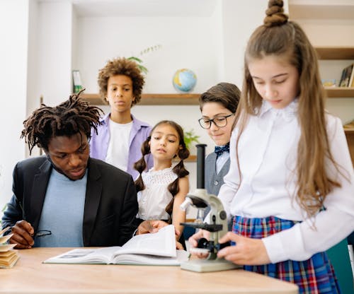 Free A Teacher with His Students in a Classroom Stock Photo