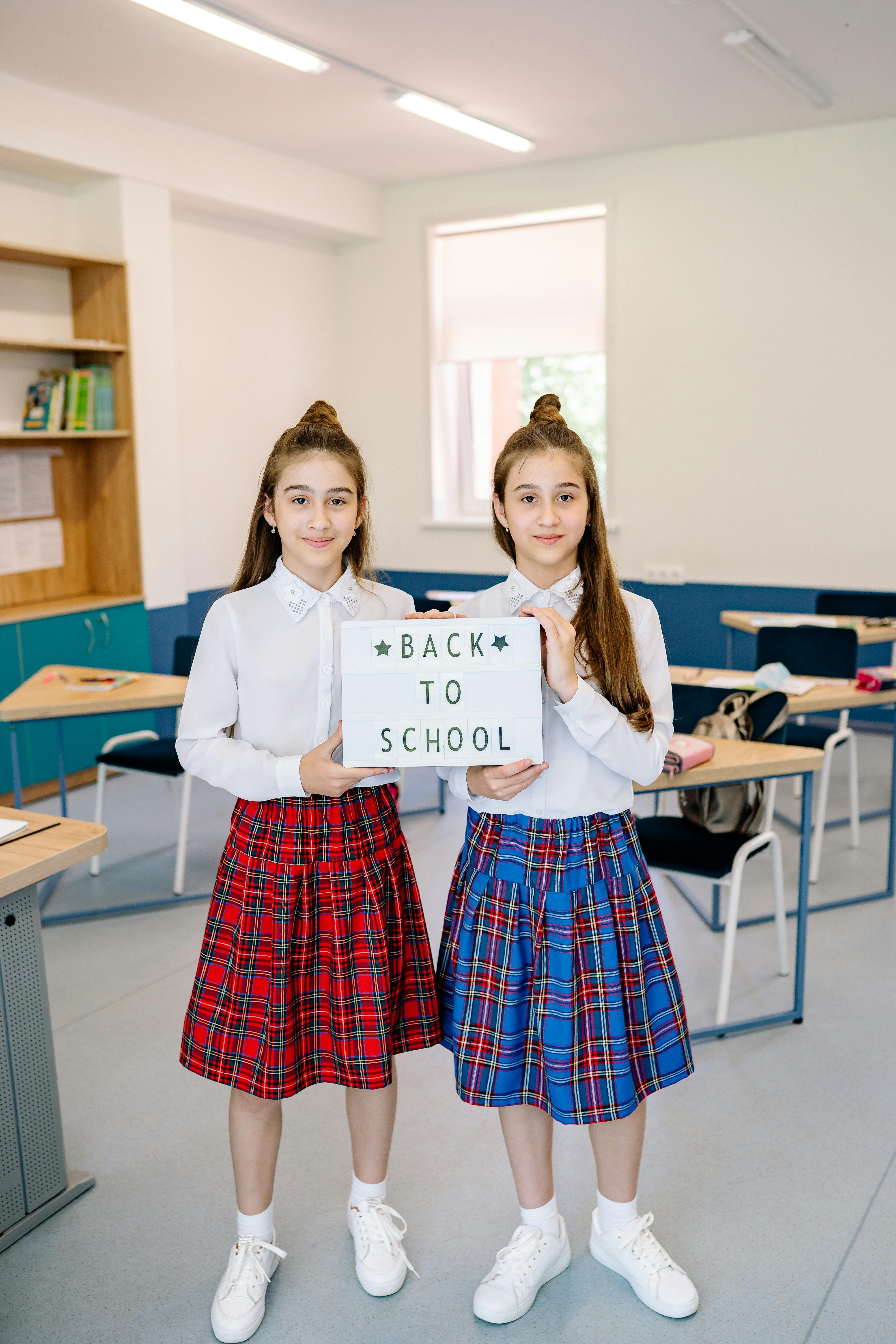 2 girl standing beside brown wooden table