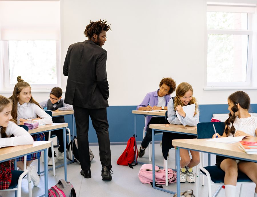 Teacher standing among students in a classroom
