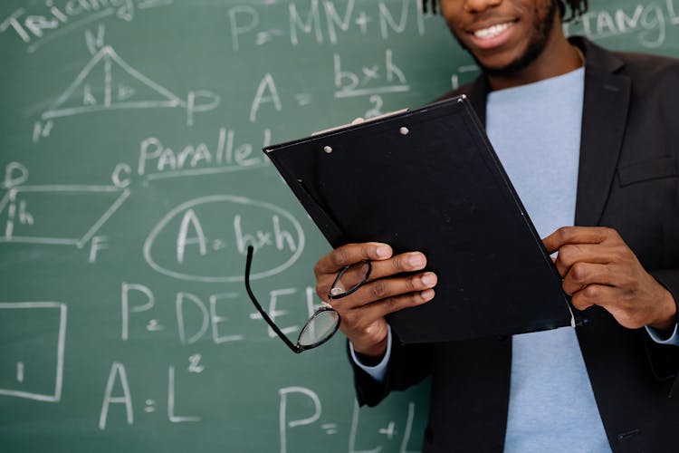 Close-up Of A Teacher Holding A Clipboard