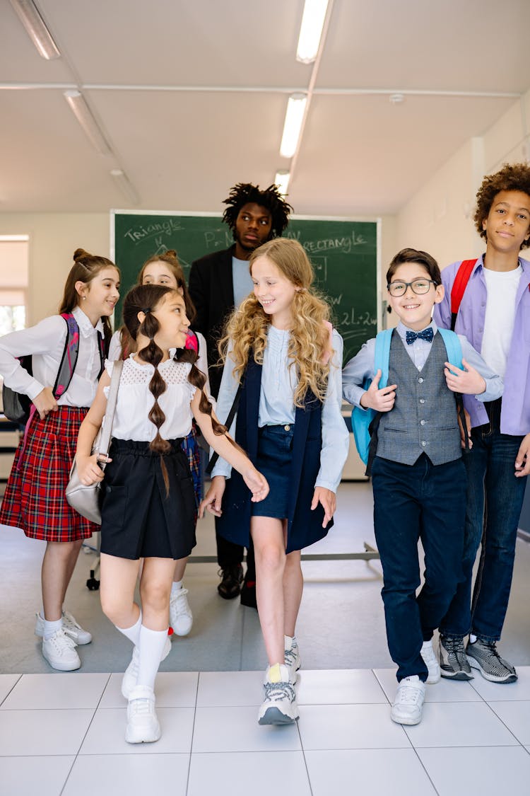 Teacher With The Students Walking In The School