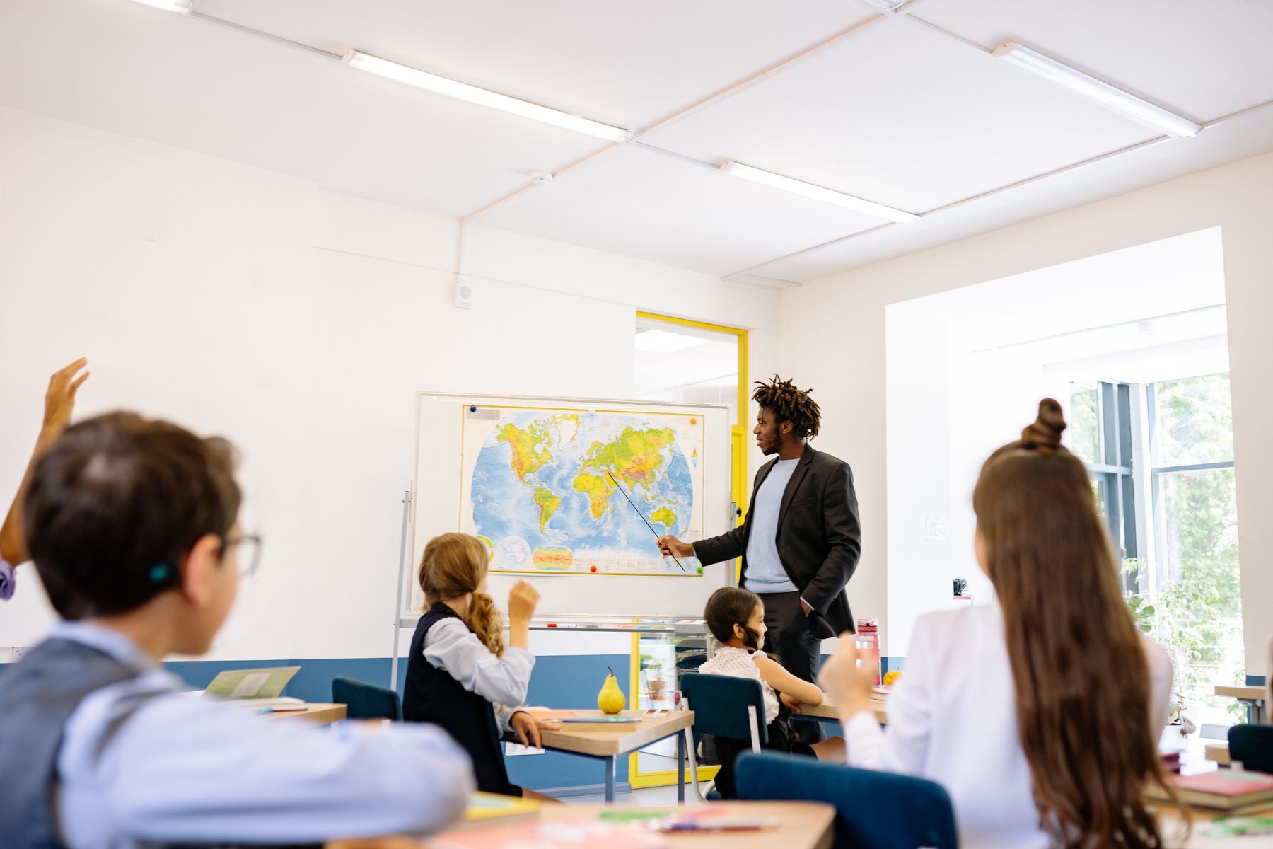 Tutor helping children learn in a small classroom