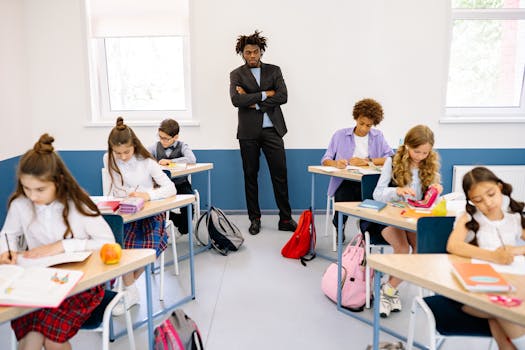 Elementary students engaged in learning with a teacher overseeing in a bright classroom.