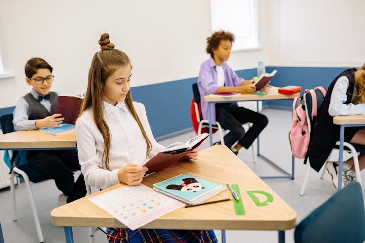 Students Reading Book In The Classroom