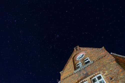 Low Angle Shot of the Starry Night and Brick Building