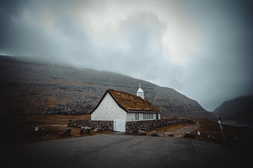 White and Brown House Near Mountain Under White Clouds