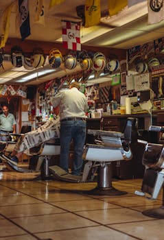 A cozy vintage barbershop with a barber attending to a client amidst retro decor and helmets.