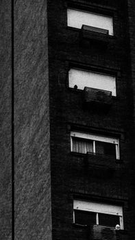 Black and white capture of a multi-storey building exterior with balconies.