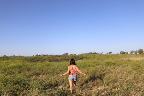 Woman Walking on Grass Field