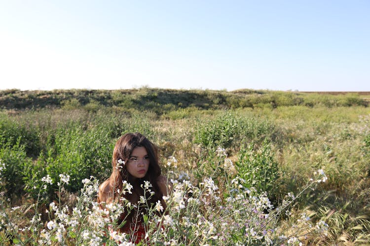 A Woman Surrounded By Plants And Flowers