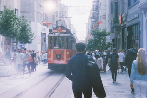 People Walking on Street Near a Tram