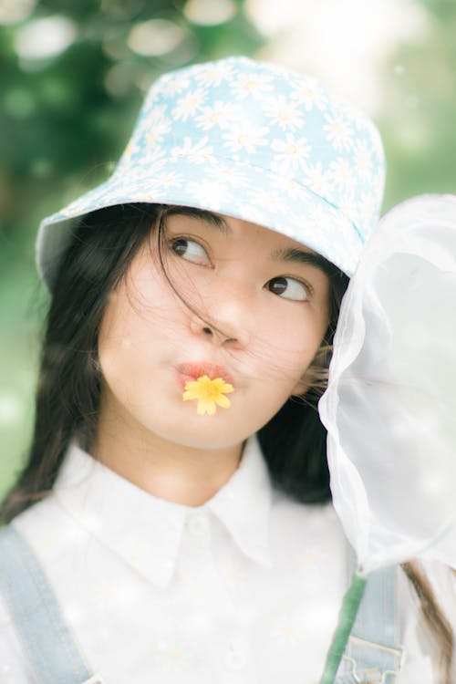 Woman with Yellow Flower on Her Lips