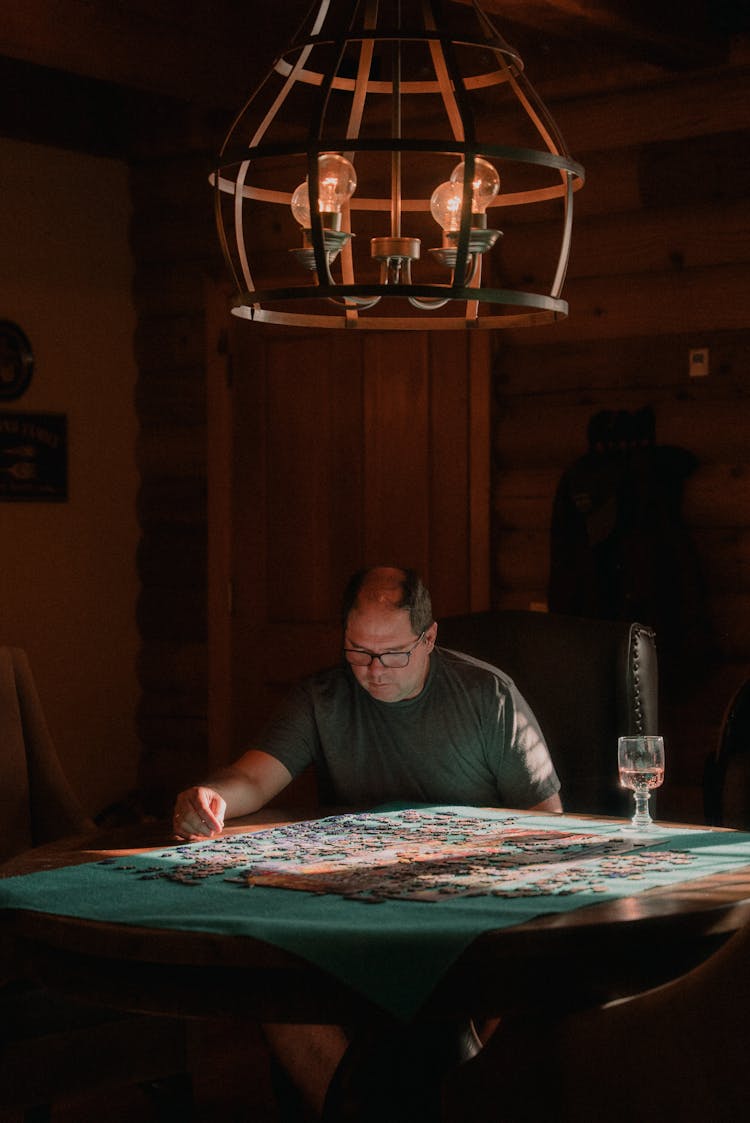 Man In Gray Shirt Doing A Puzzle