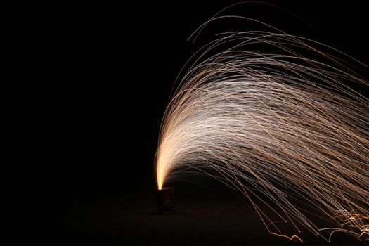 Captivating long exposure photo capturing a firework display with vivid sparks against a dark night sky.