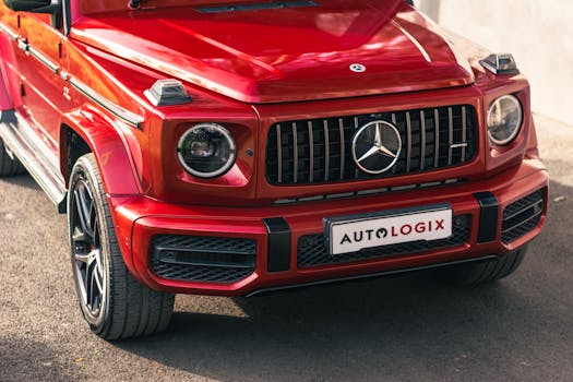 Close-up of a red Mercedes SUV with a custom license plate on a sunny day.