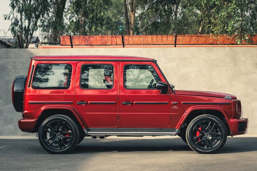 Stylish red Mercedes-Benz G Class SUV parked outdoors, showcasing luxury and design.