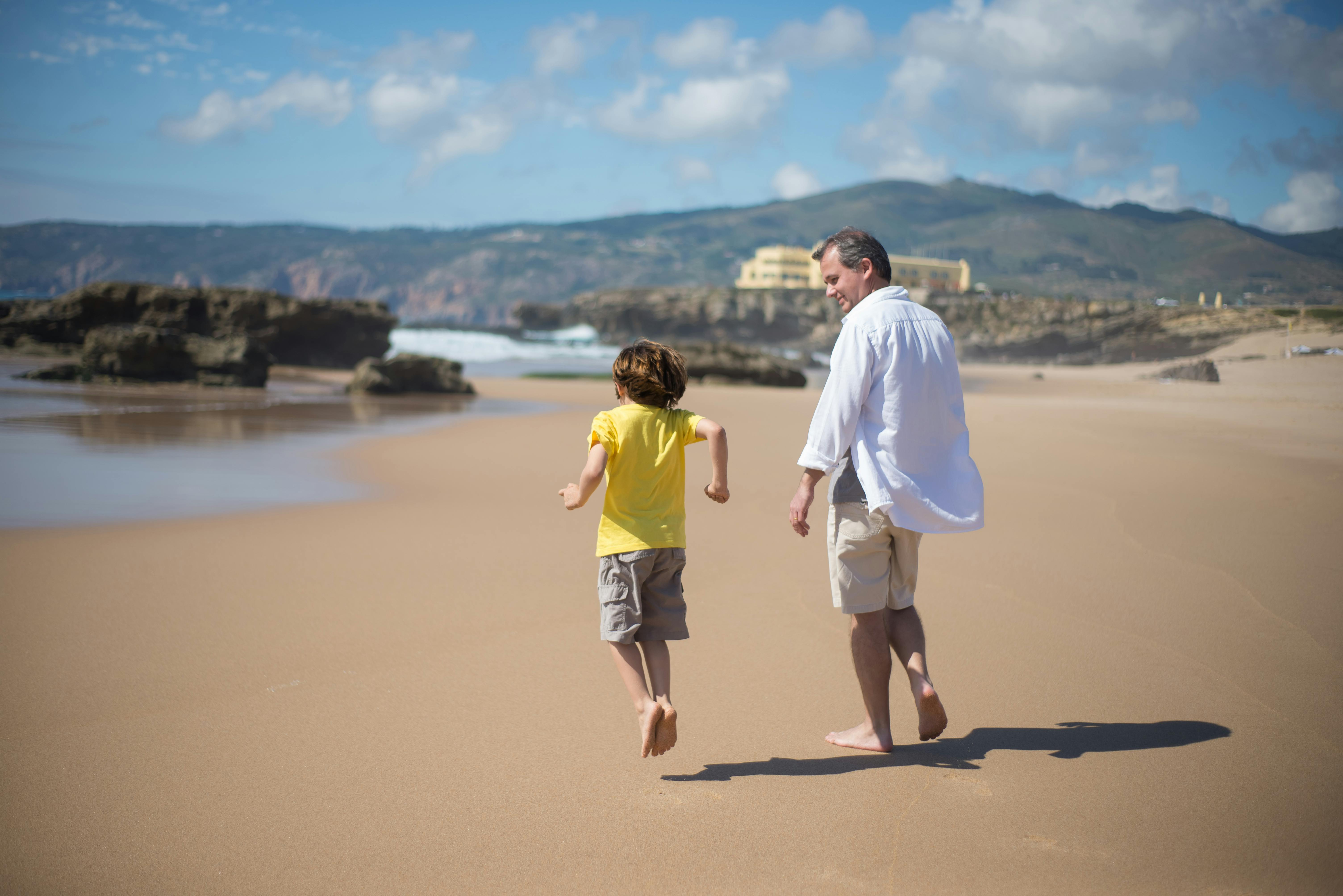 Father and Son Walking on the Beach · Free Stock Photo