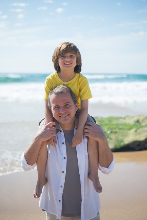 Free A joyful moment between father and son at a sunny beach in Portugal. Stock Photo