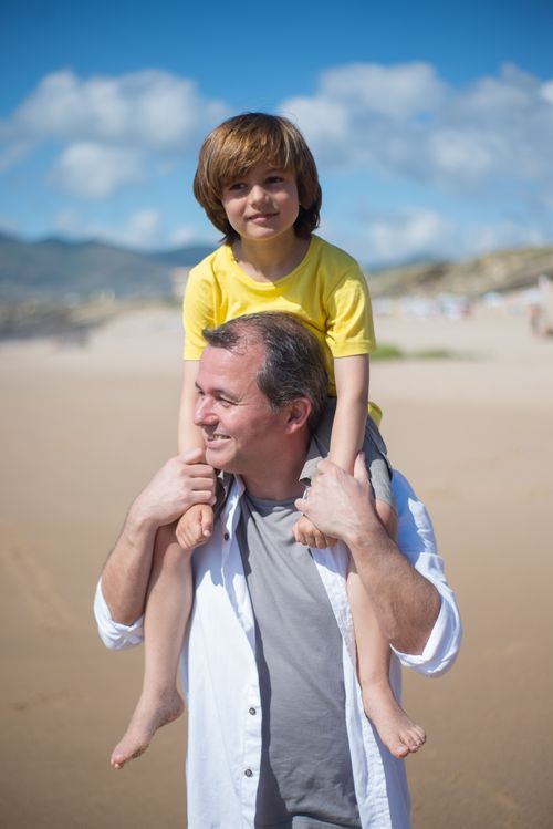 Free Father and son bonding at the beach on a bright sunny day in Portugal. Stock Photo