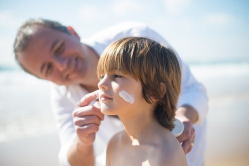 Free A Man Applying a Sunscreen on His Son's Face Stock Photo