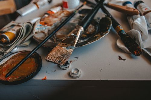 Free A cluttered artist's workspace with paintbrushes and palette, showcasing creativity. Stock Photo