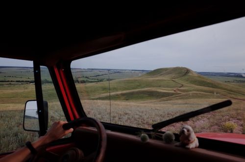 Free View of rolling hills from inside a vehicle, showcasing a countryside drive. Stock Photo