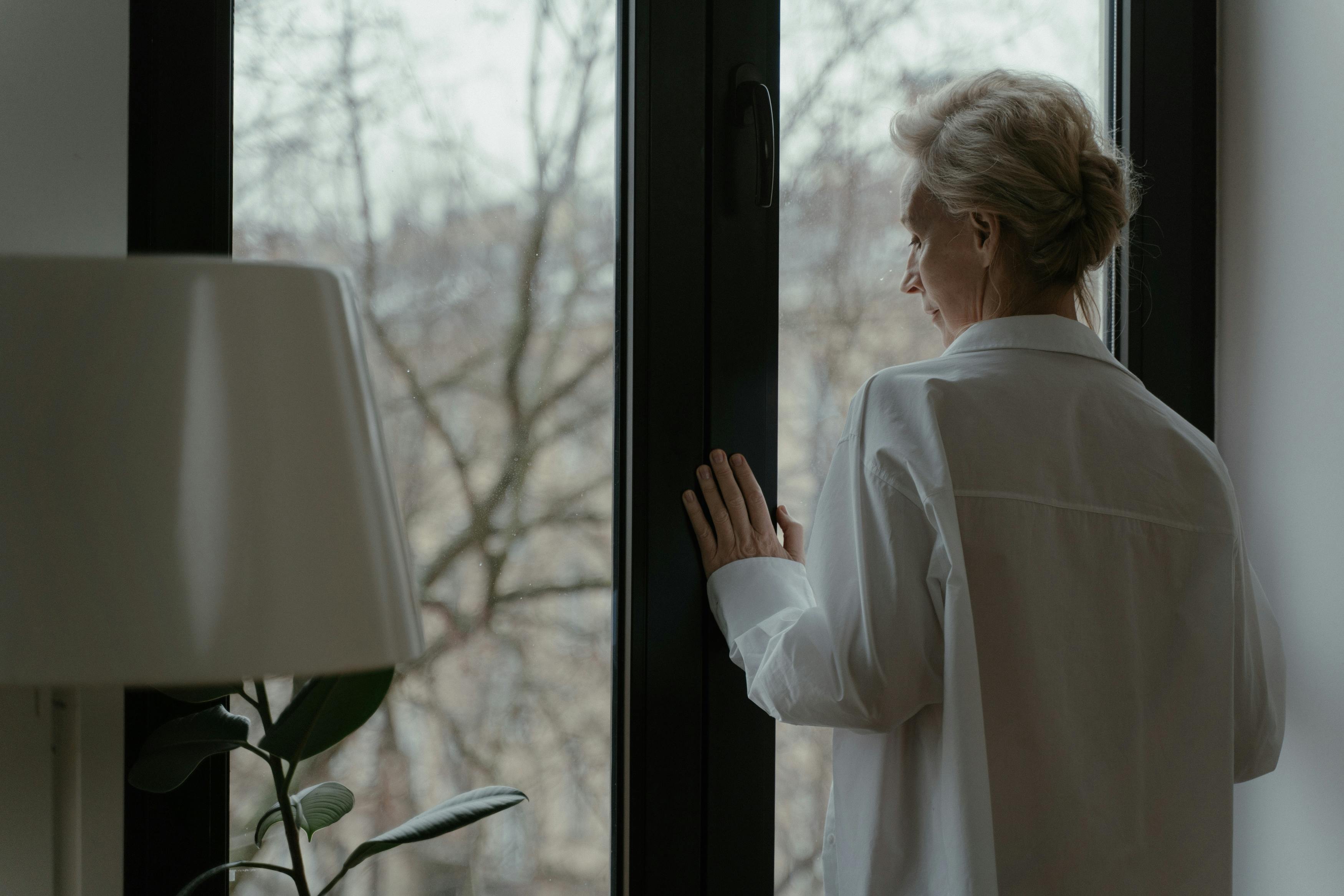 an elderly woman looking through the window