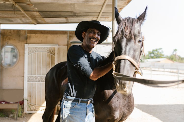 A Man Standing Beside Horse