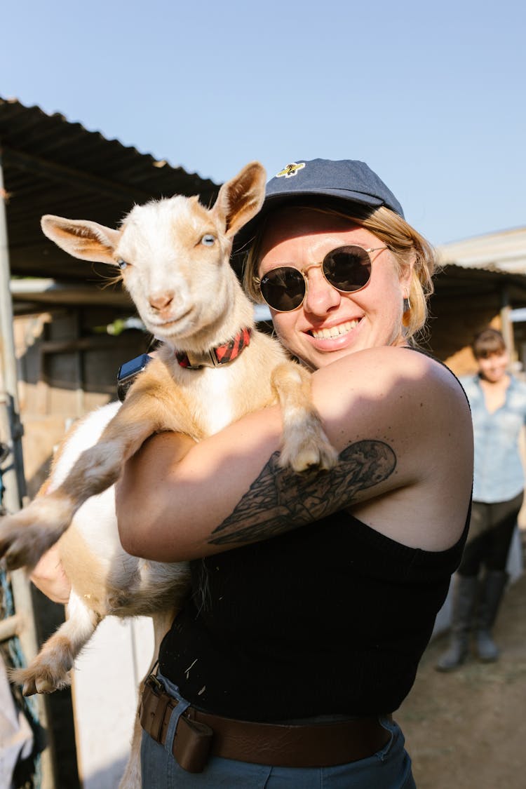 A Woman Carrying A Goat 