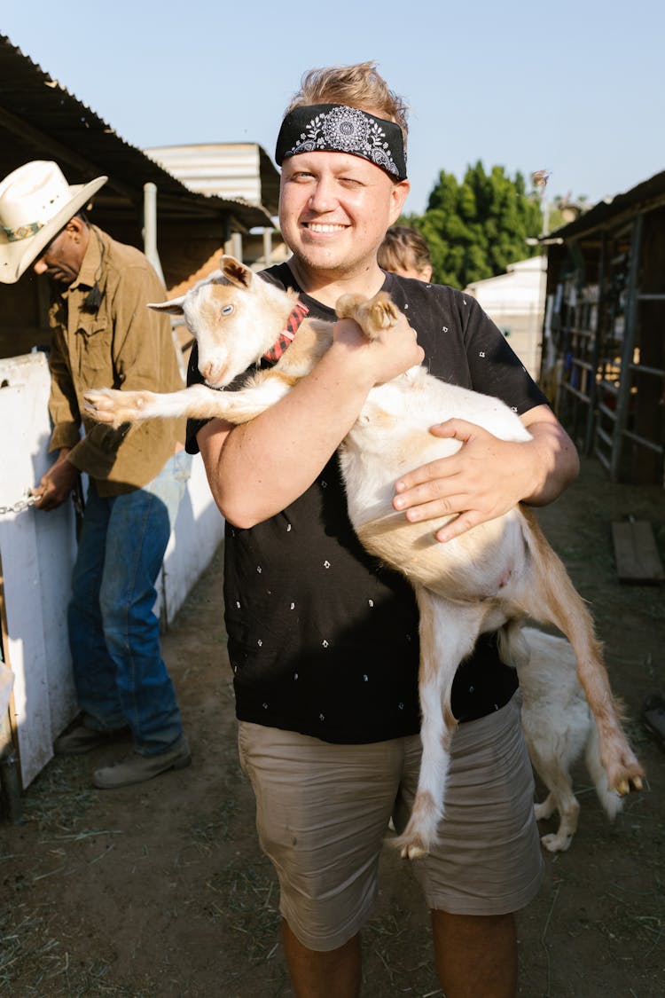 A Man Carrying A Goat 