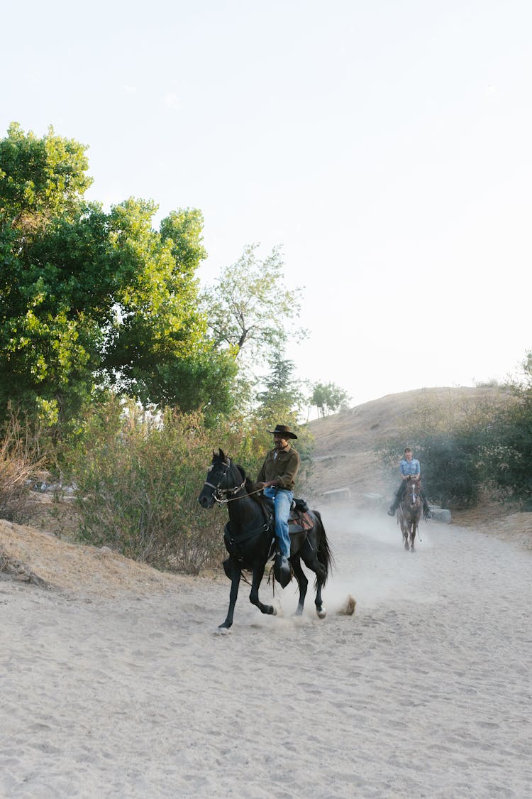 A Man And A Woman Riding Horses