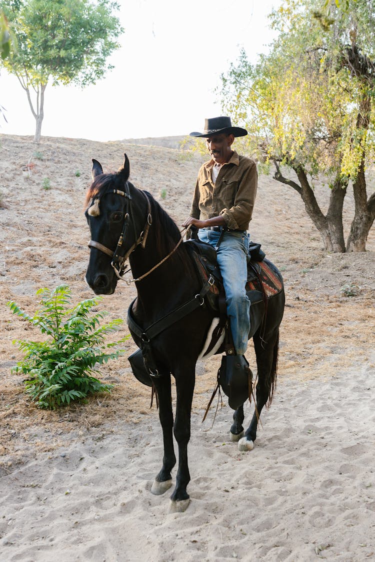 A Man Riding A Black Horse