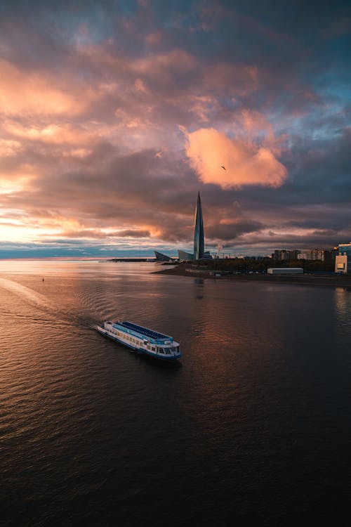 Ship Sailing in Sea under Pink Sunset