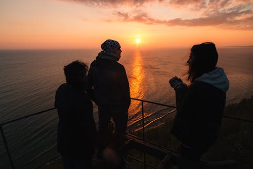 Silhouettes of People on Ship at Sunset