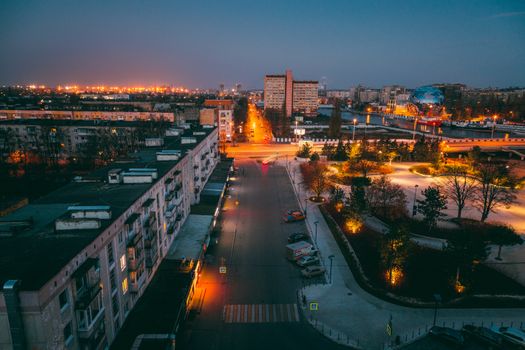 A vibrant aerial shot of a city at night with illuminated streets and buildings.