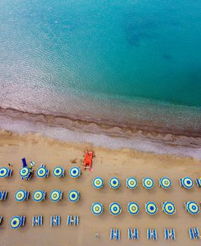 Aerial shot of Santa Marina beach with colorful umbrellas and shoreline in Campania, Italy.