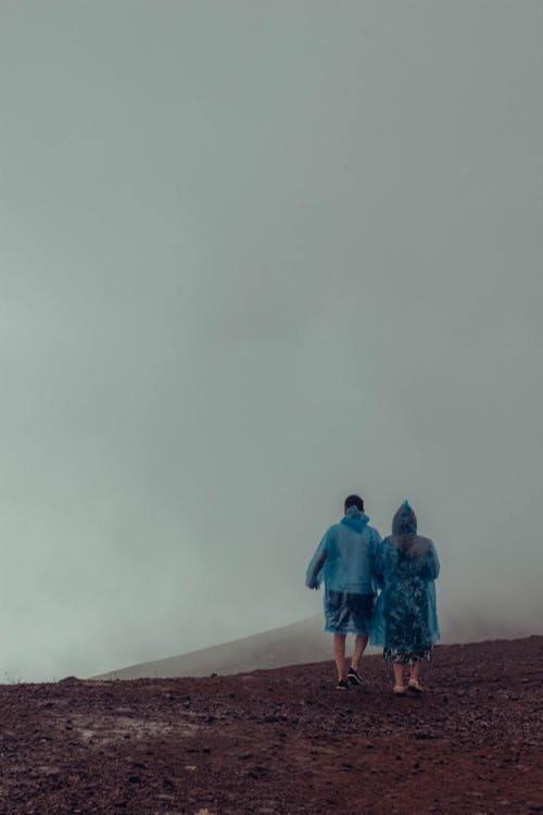 Free Couple Walking on a Murky Dirt Land  Stock Photo