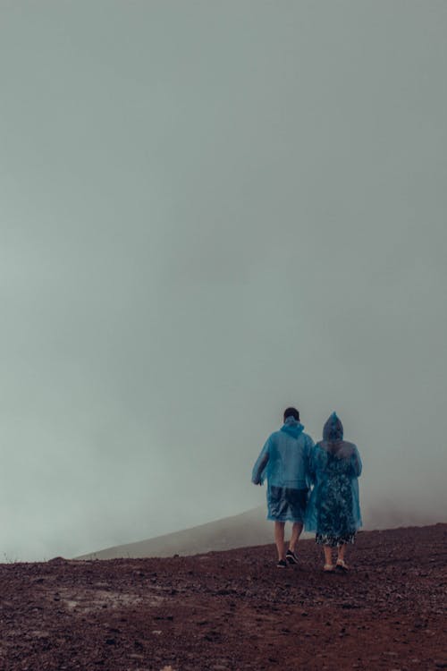 Couple Walking on a Murky Dirt Land 